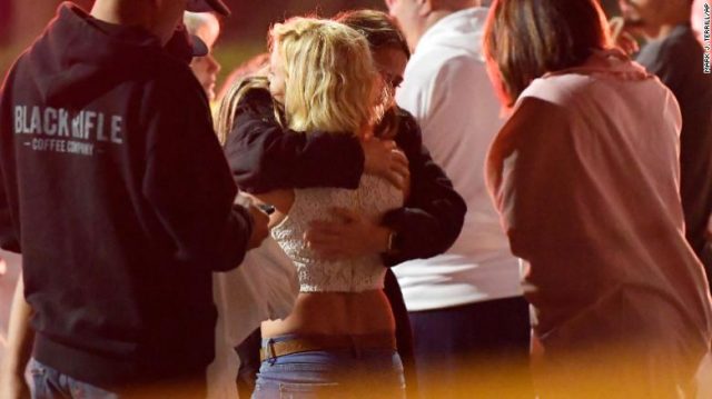 People console one another near the shooting scene Thursday. 