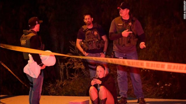 Sheriff's deputies speak to a potential witness near the scene Thursday. 