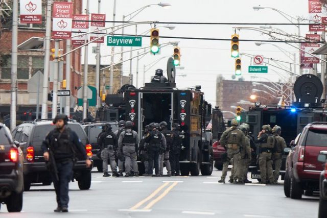 Law enforcement gathers near the scene following reports of gunfire, Tuesday, Dec. 10, 2019, in Jersey City, N.J. AP Photo/Eduardo Munoz Alvarez) AP